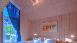 A wooden cabin bedroom with a bed, a nightstand, and a painting on the wall. - Exclusive skandinavisches, Rechlin (Rechlin)