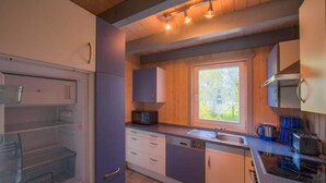 Een kleine keuken met een magnetron, spoelbak en kastjes.