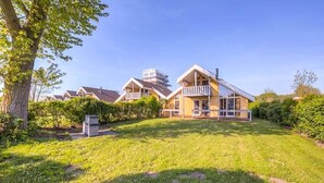 Une rangée de maisons avec une pelouse verdoyante et un arbre.