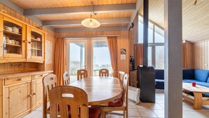 Ein Holzinterieur mit Esstisch, Stühlen und einer Couch.
