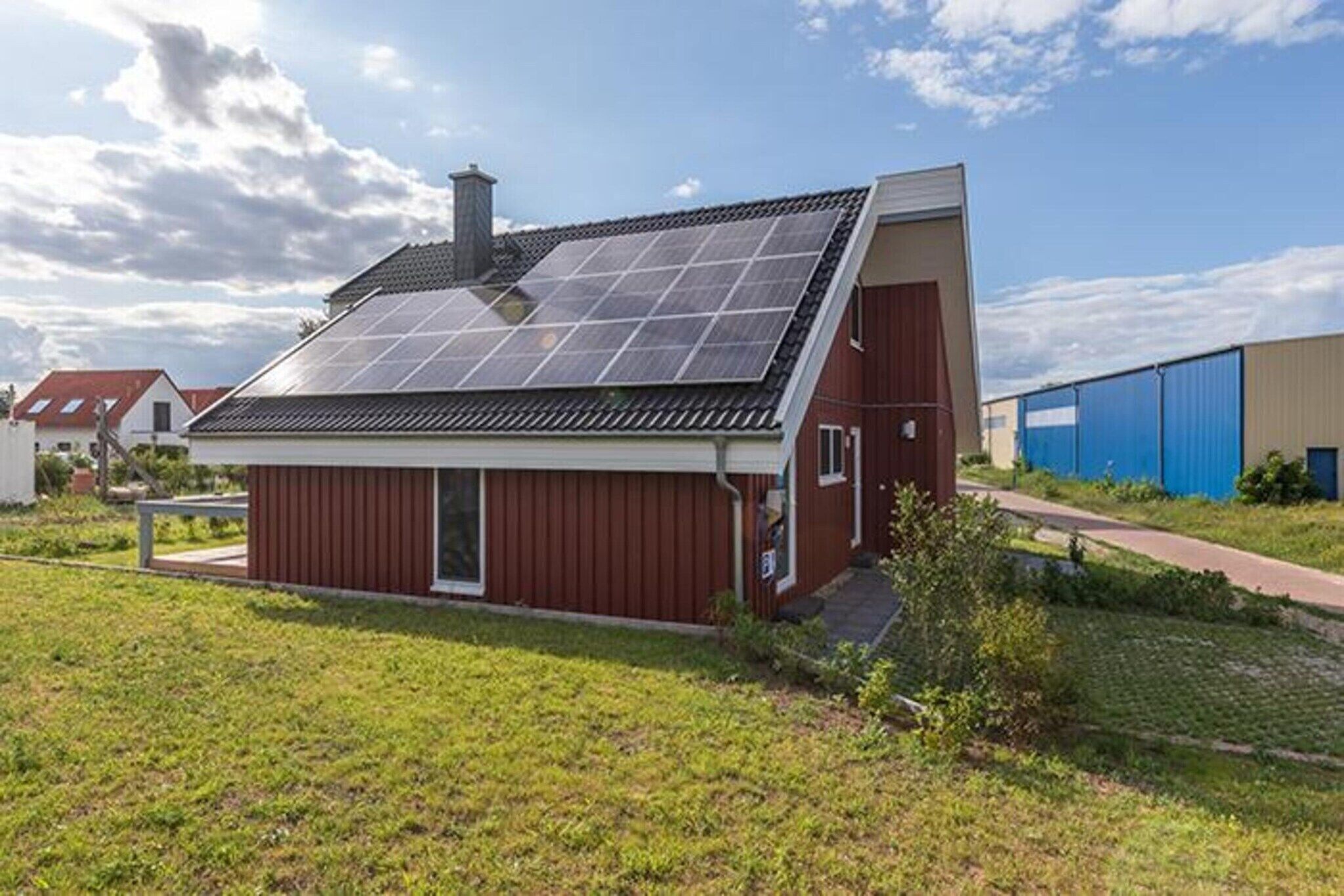 Une maison moderne avec un toit en pente et des panneaux solaires.