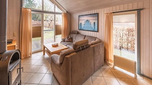 A cozy living room with a sofa, a coffee table, and a grill. - exklusives skandinavisches Ferienhaus (Granzow)
