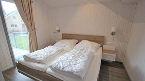 Une chambre à coucher avec un lit en bois, du linge de lit blanc et deux lampes de chevet.