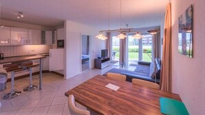 Eine moderne Küche mit Essbereich, Fernseher und Blick ins Freie.