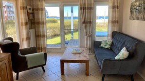 A living room with a sofa, armchair, and a small table. - liebevoll eingerichtetes Appartement (Rechlin)