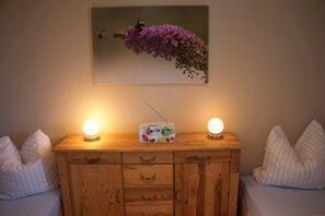 A wooden dresser with two bedside lamps, a radio, and a framed picture on the wall. - tolles Appartment in der Seenplatte (Rechlin)