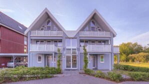 A two-story building with a symmetrical facade, a central entrance, and balconies on each floor. - tolles Appartment in der Seenplatte (Rechlin)