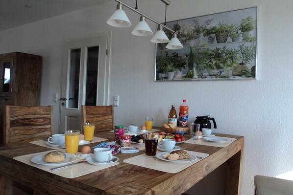 A breakfast table set with plates, cups, and a variety of breakfast items. - liebevoll eingerichtetes Appartement (Rechlin)