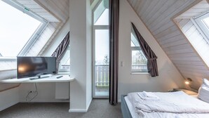 A bedroom with a desk, a bed, and a window. - exklusives Appartement in Rechlin (Rechlin)
