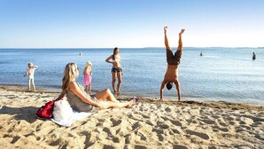 A beach scene with people engaging in various activities.