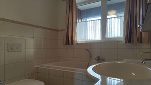 Une salle de bain comprenant des toilettes, une baignoire et un lavabo.