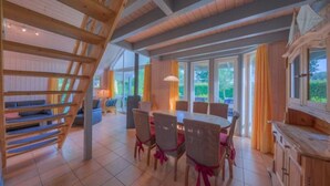 A spacious dining area with a high wooden ceiling and large windows. - Ferienhaus im skandinavischen Stil (Granzow)