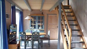 A wooden interior with a dining area, a staircase, and a cabinet with dishes. - skandinavisches Ferienhaus in Mirow (Granzow)