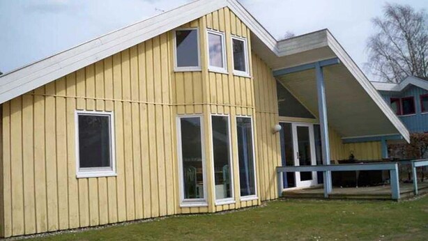 A yellow building with a gabled roof and large windows. - skandinavisches Ferienhaus in Mirow (Granzow)