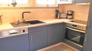 A modern kitchen with a Bosch dishwasher, a sink, a coffee maker, and an oven. - skandinavisches Ferienhaus in Mirow (Granzow)
