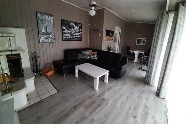 A living room with a sofa, a coffee table, and a fireplace.