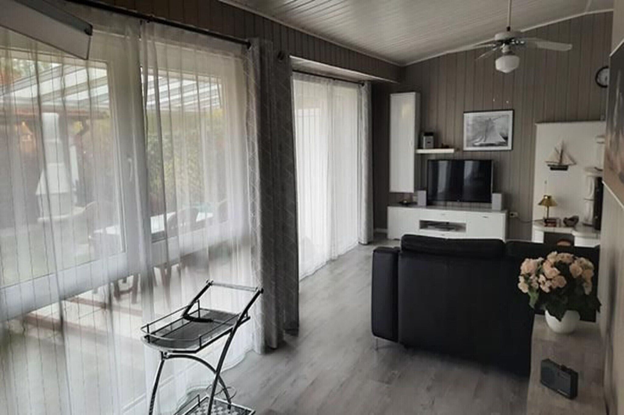 Una sala de estar moderna con un sofá, un televisor y un comedor con una mesa y sillas.