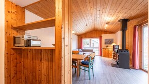 Un interno in legno con zona pranzo, cucina e camino.