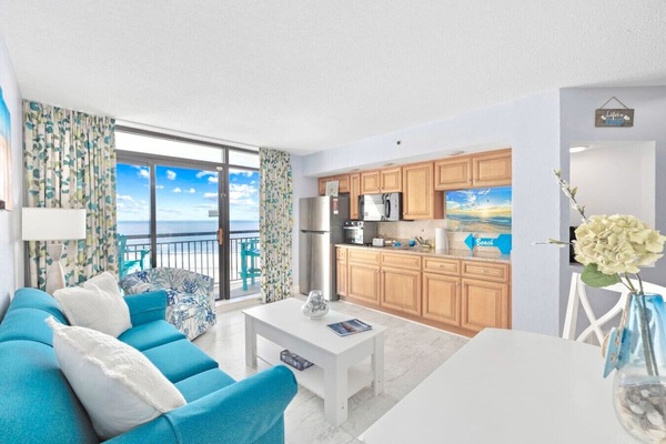 Experience breathtaking oceanfront views from the living room in Tower B at Beach Cove Resort. Relax in a spacious, light-filled space overlooking the Atlantic, perfect for your coastal getaway.