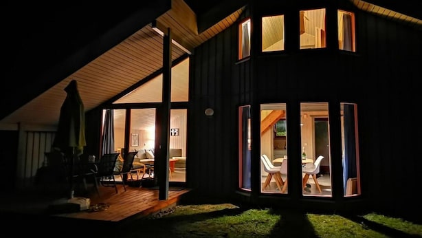 A modern house with a wooden deck and large windows. - skandinavisches Ferienhaus in Mirow (Granzow)
