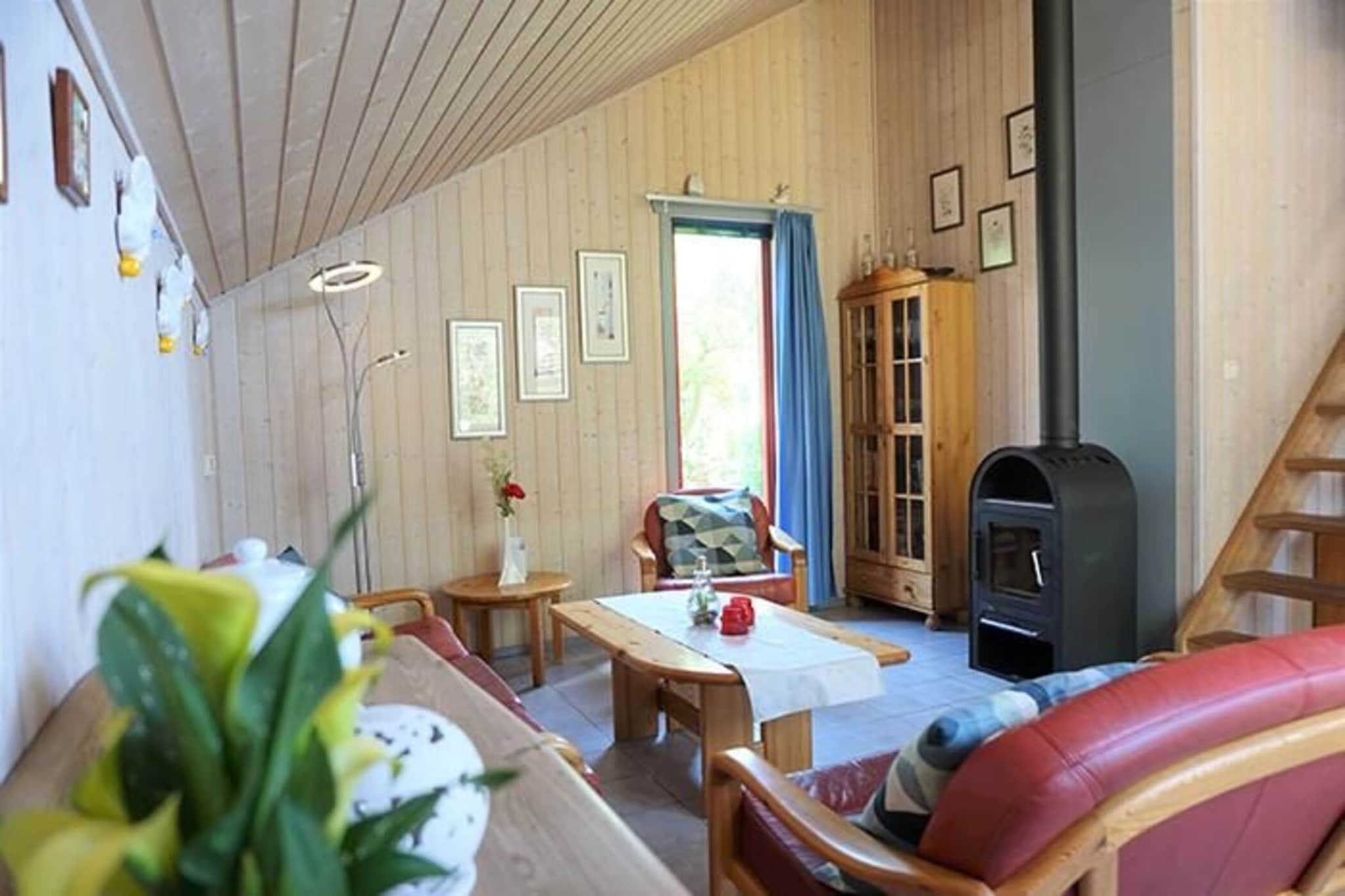 Una sala de estar acogedora con detalles de madera, un sofá, una mesa y una chimenea.
