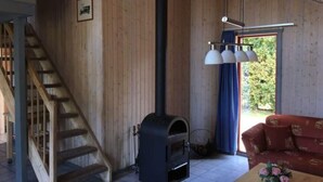 Un interno in legno con camino, una scala e un divano.
