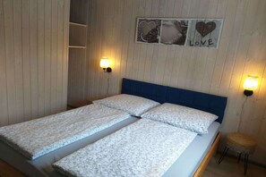 A room with a bed, two wall-mounted lamps, and a poster on the wall. - exklusives skandinavisches Ferienhaus (Granzow)