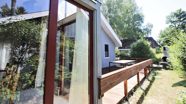 A modern house with a wooden deck and a small window. - Ferienhaus im Ferienpark Mirow (Granzow)