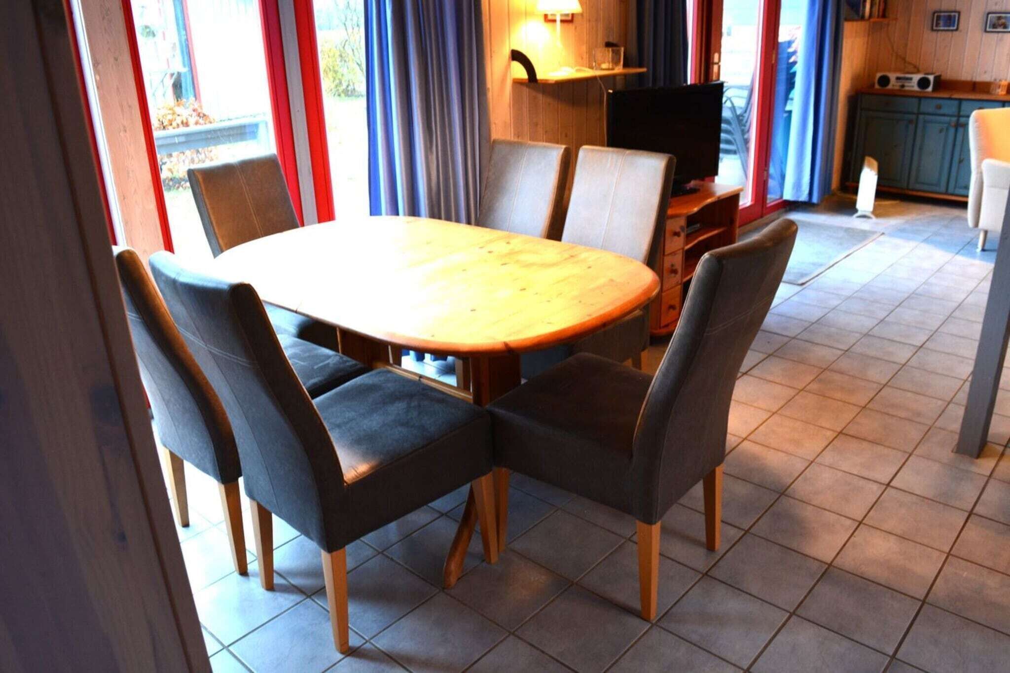 Un comedor con una mesa redonda de madera y cuatro sillas tapizadas.