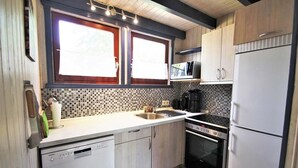 Una cocina equipada con lavavajillas, estufa, microondas y refrigerador.
