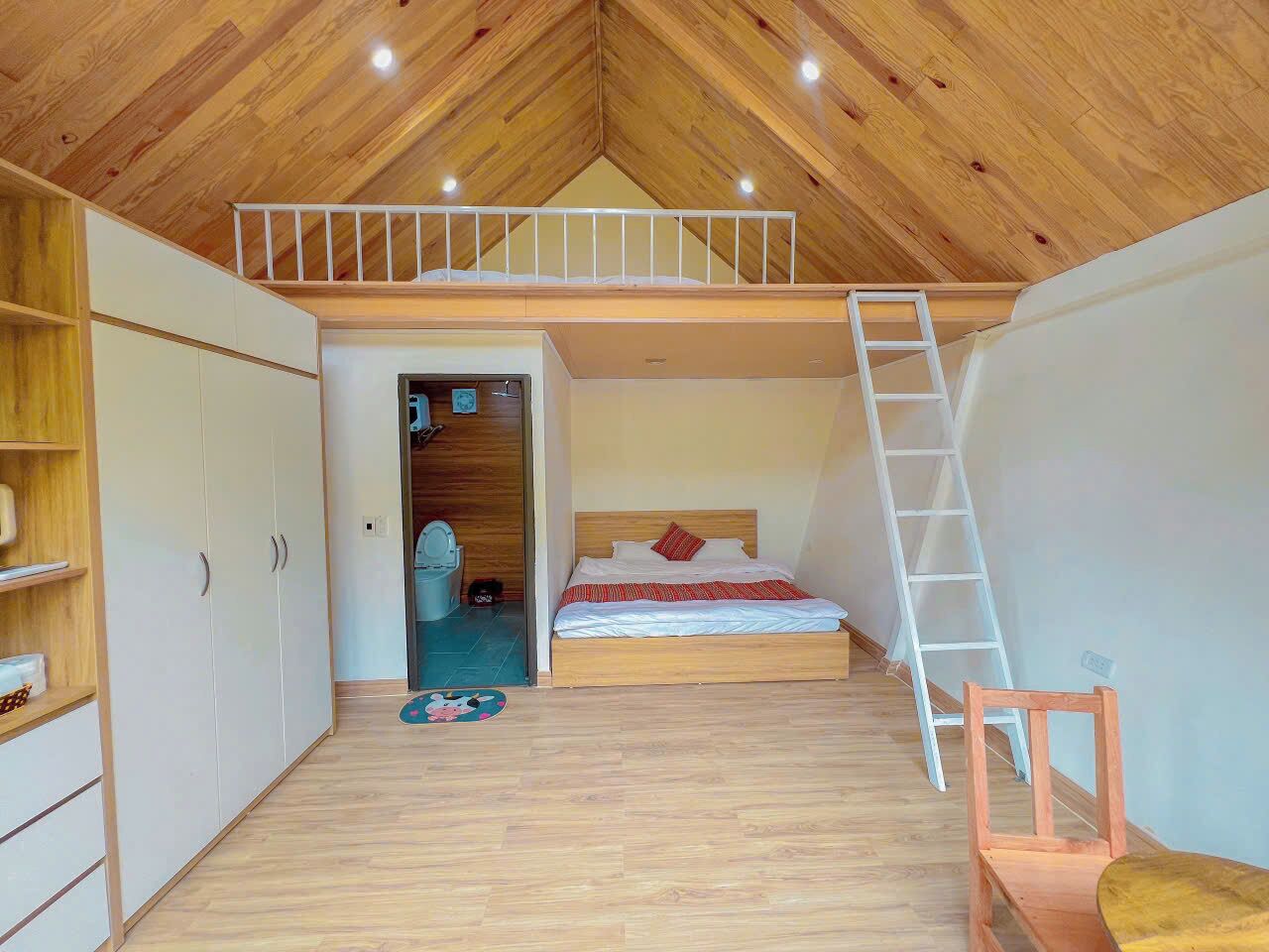 Quarto com beliche, piso de madeira, escada branca e uma cadeira de madeira pequena.