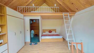 A bedroom with a loft bed, wooden flooring, a white ladder, and a small wooden chair.