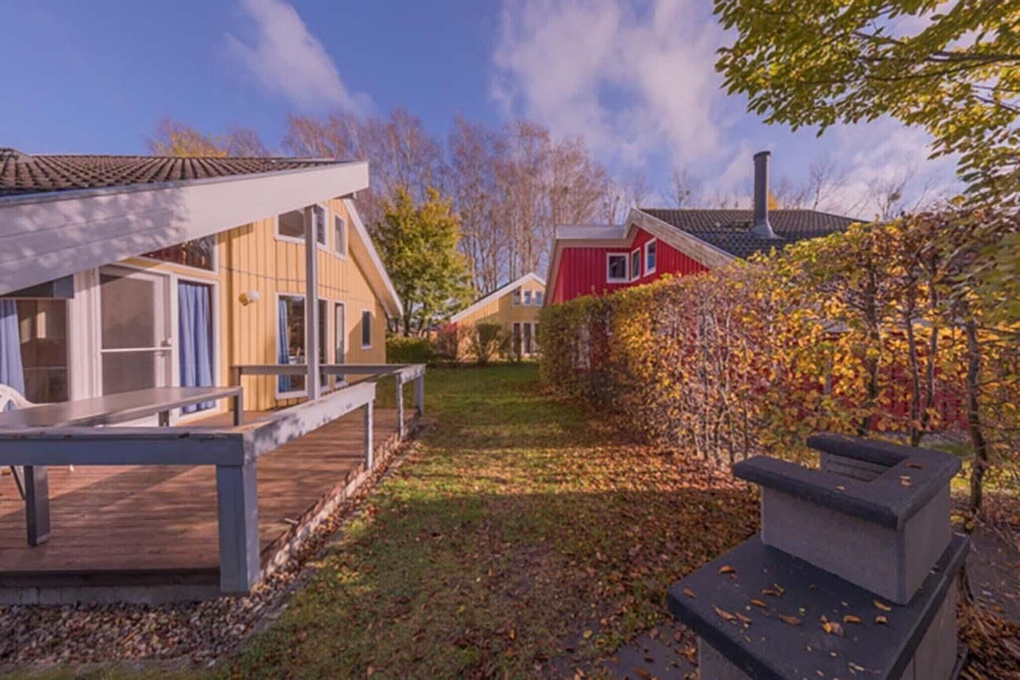 Un quartier résidentiel avec des maisons, une terrasse en bois et un barbecue.