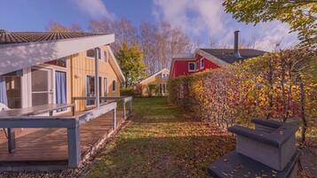 Un quartier résidentiel avec des maisons, une terrasse en bois et un barbecue.