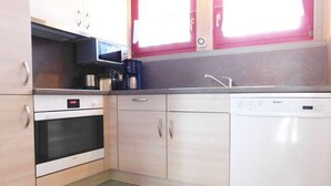 A kitchen with a microwave, oven, and dishwasher. - skandinavisches Ferienhaus in Mirow (Granzow)