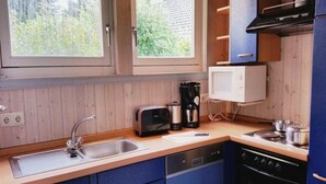 Pieni, käytännöllinen keittiö, jossa on pesuallas, leivänpaahdin, kahvinkeitin, mikroaaltouuni ja liesi.