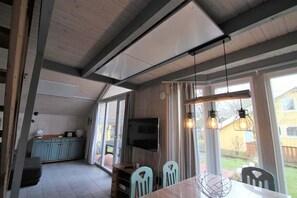 Un espace repas comprenant une table, des chaises et des luminaires suspendus.