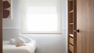 Un dormitorio con cama, ventana y armario.
