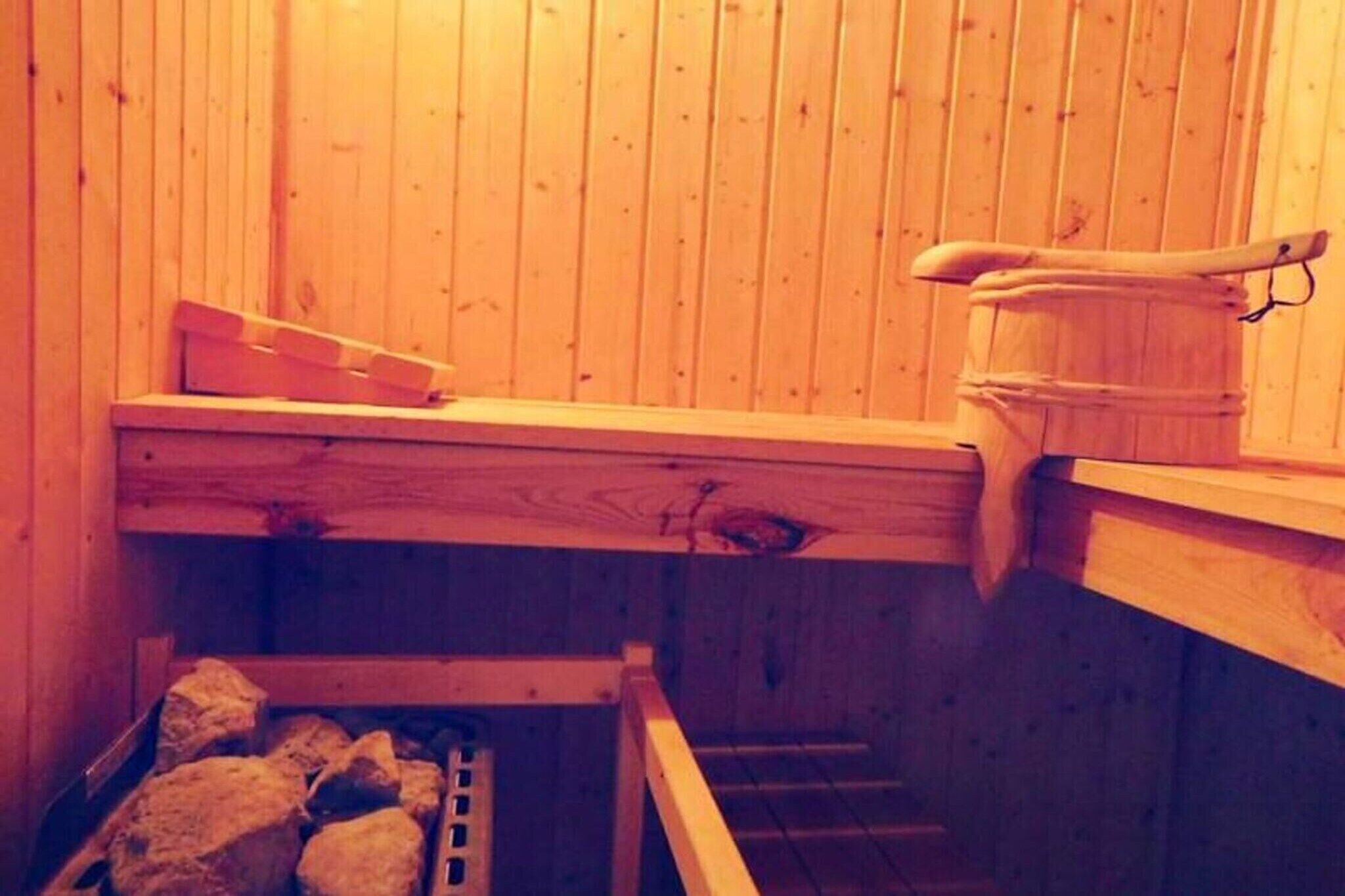 A wooden sauna with benches and a stone bench.