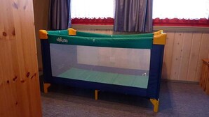 A small, enclosed playpen with a green and blue color scheme, featuring a mesh top and yellow legs. - skandinavisches Ferienhaus in Mirow (Granzow)