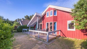 A red building with a covered patio area and a small deck.