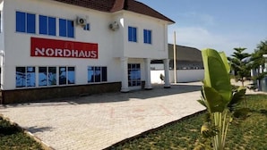 Un edificio Nordhaus con entrada de baldosas, ventanas amplias y camino de entrada pavimentado.