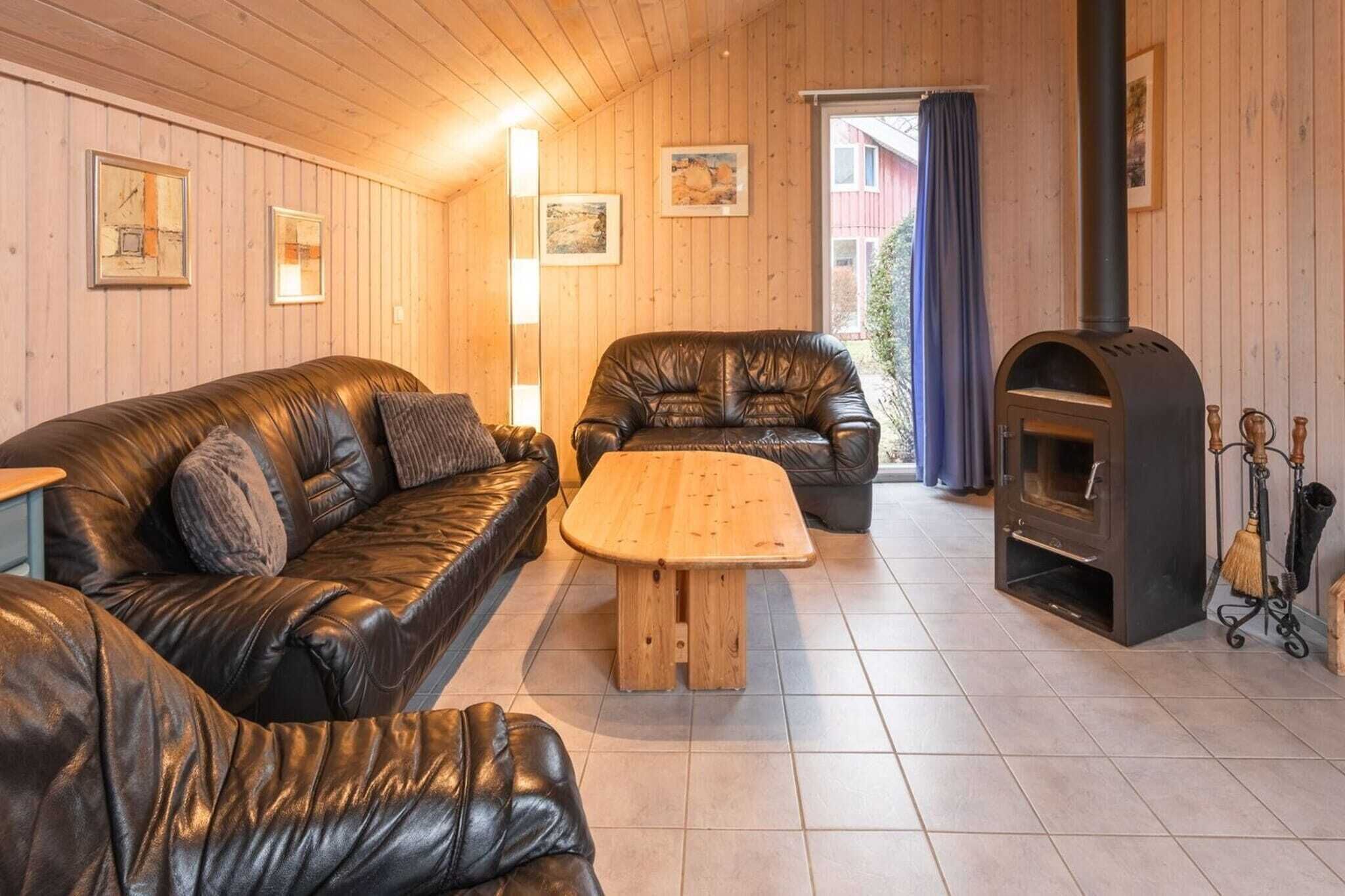 A cozy room with a leather sofa, a wooden coffee table, and a fireplace.