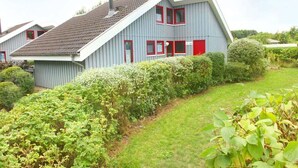 A residential building with a sloped roof, red-framed windows, and a chimney. - Ferienhaus im Ferienpark Mirow (Granzow)
