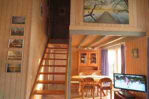 A wooden interior with a staircase, dining area, and a TV. - Ferienhaus im skandinavischen Stil (Granzow)
