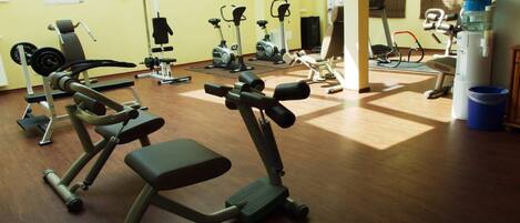 A gym with various exercise equipment including treadmills, stationary bikes, and weight machines.