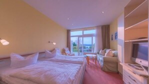 A hotel room with two beds, a TV, a desk, and a chair. - Gemütliches Appartement mit skandinavischem Flair (Granzow)