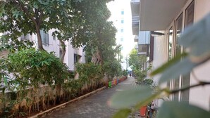 Un estrecho callejón empedrado con una bicicleta estacionada a la derecha, bordeado por edificios y árboles.