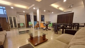 Una sala de estar moderna con una mesa de centro de vidrio, un sofá y un comedor con sillas.