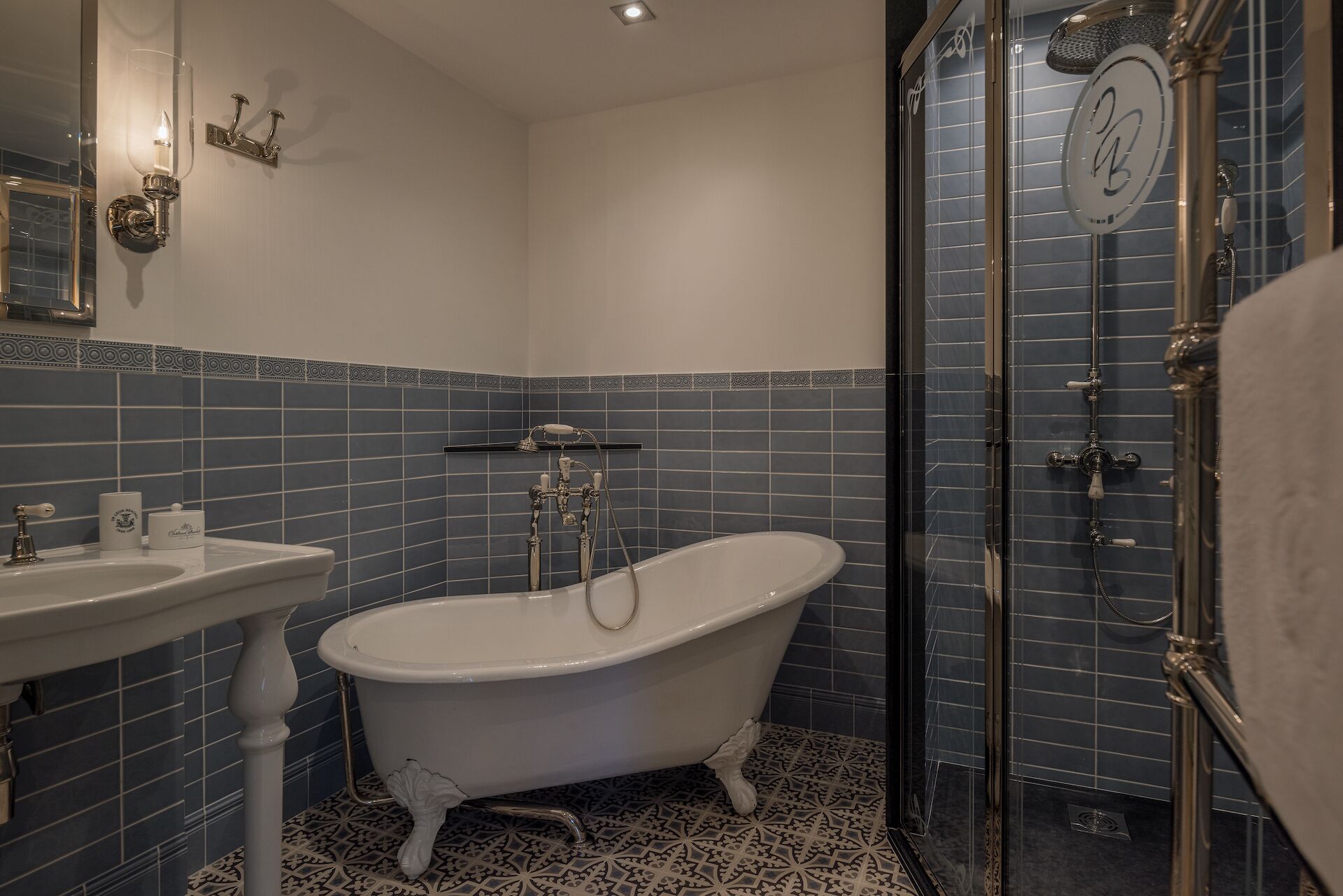 A bathroom with a freestanding bathtub, a sink, and a glass-enclosed shower area.
